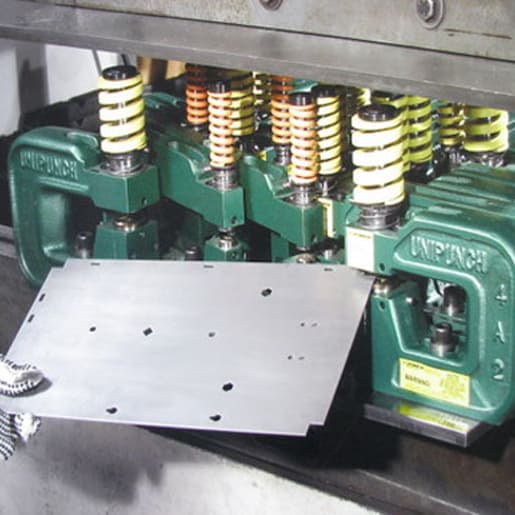 One Hit Many Holes - Here a dedicated setup on a keyed mounting template produces multiple operations including corner notching, round and shaped hole punching and lance & form. UniPunch engineers can help layout the tooling for your part.